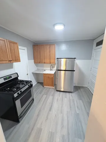 a kitchen with a refrigerator and a stove top oven