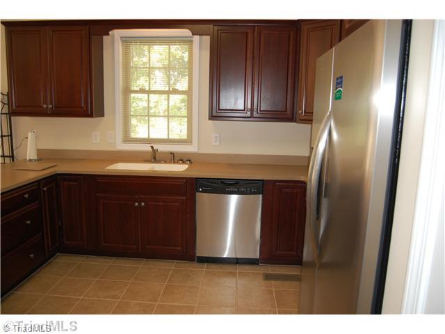 2725 Rowe Road Lexington, NC 27295 - Photo 4 of 16 Kitchen. Beautiful Corian countertops, cherry cabinets, tile floor and like new stainless steel appliances adorn this open kitchen and flows openly into Dining room and living area.