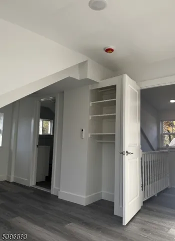 a view of a hallway with wooden floor and closet