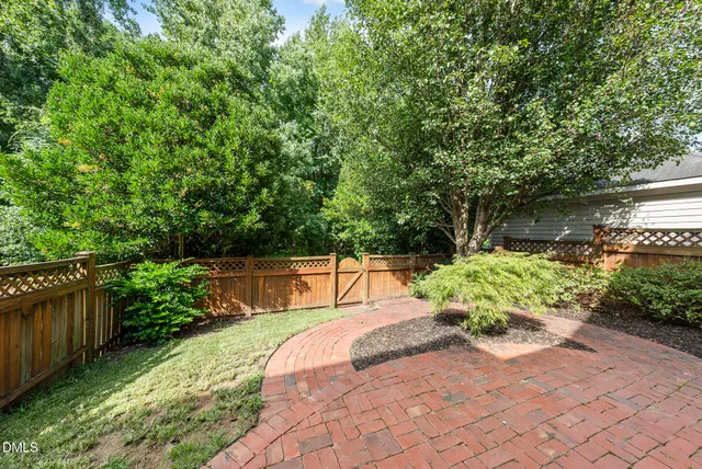 a view of a backyard with potted plants and wooden fence