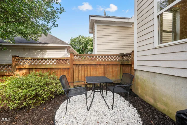 a view of a chairs and table in back yard of the house
