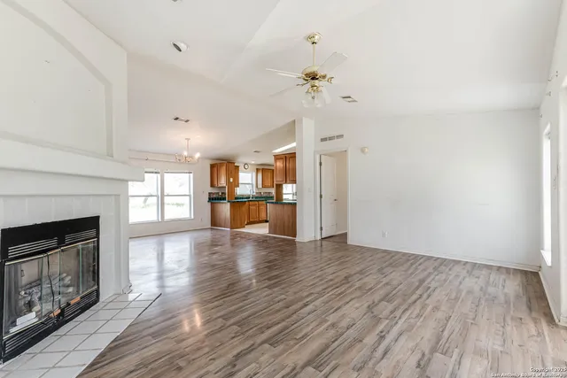 a view of empty room with wooden floor and fireplace