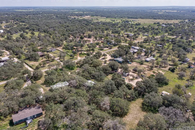 an aerial view of house with yard and mountain view in back