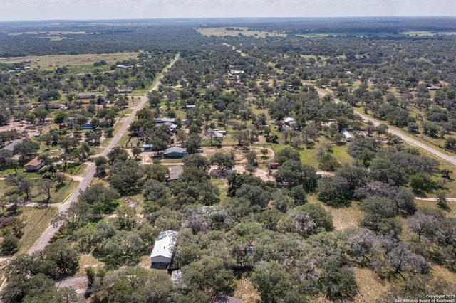 an aerial view of house with yard and mountain view in back