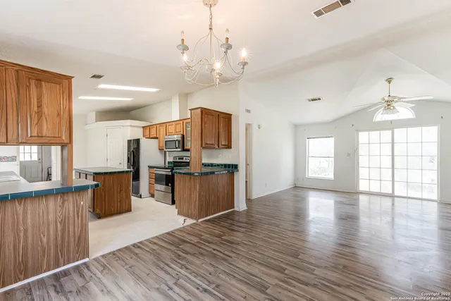 a large kitchen with cabinets wooden floor and stainless steel appliances