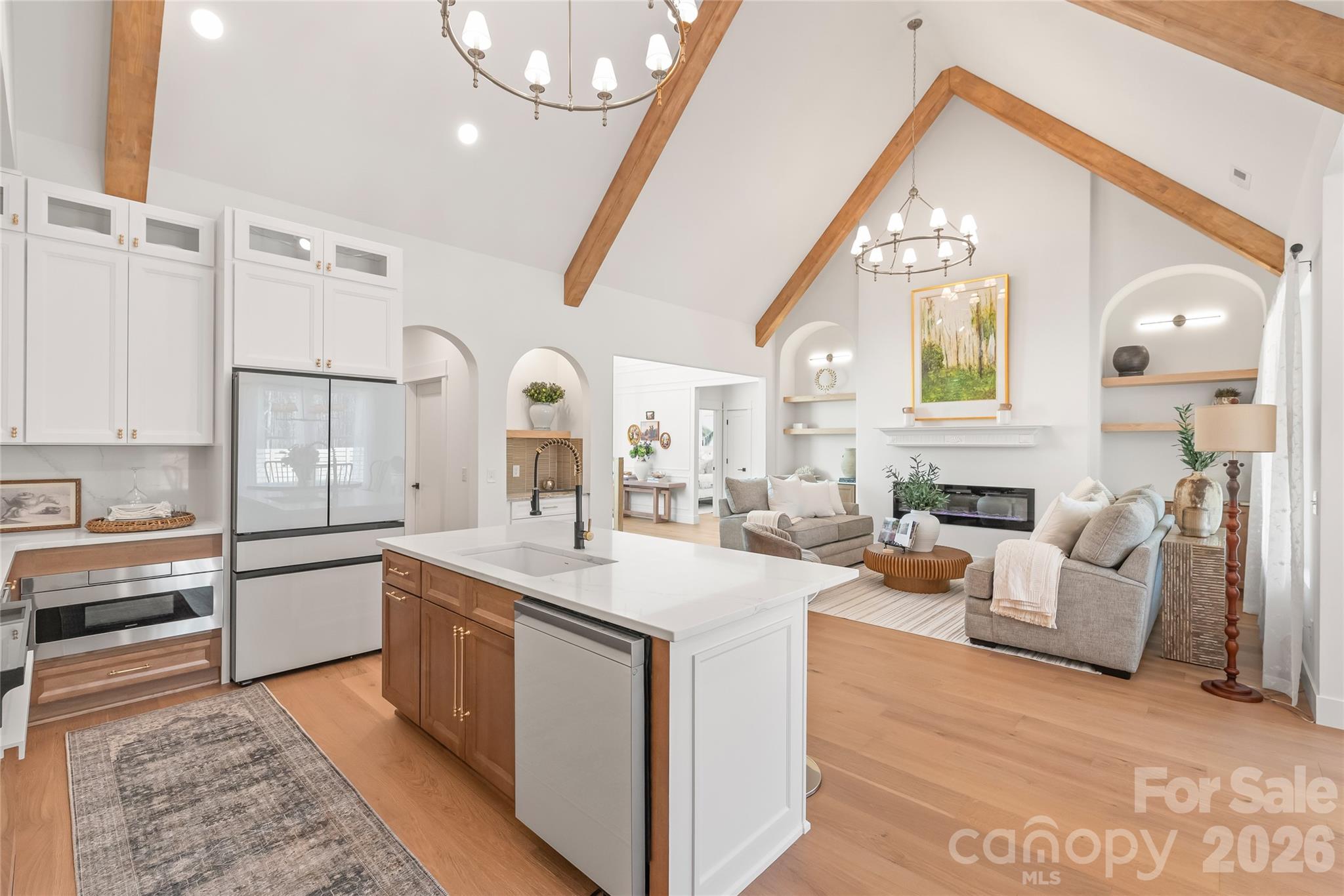 312 Rehobeth Road Waxhaw, NC 28173 - Photo 15 of 41 a large white kitchen with a stove a sink dishwasher and a fireplace with wooden floor