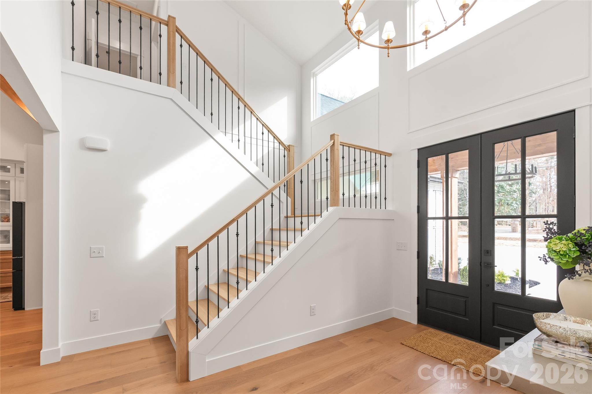 312 Rehobeth Road Waxhaw, NC 28173 - Photo 6 of 41 a view of an entryway with wooden floor leading to a furnished livingroom and windows