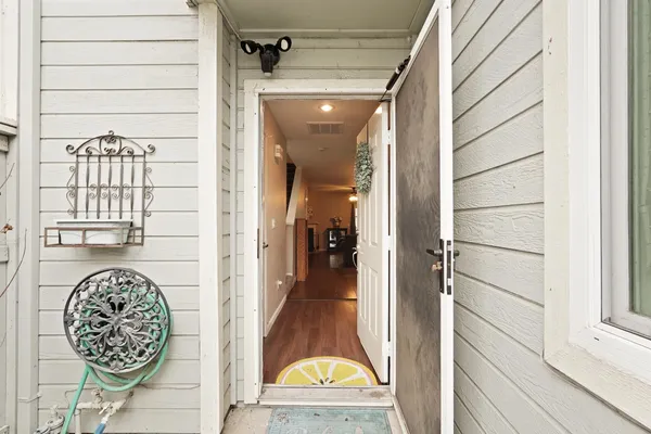 a view of a hallway with wooden floor and a bathroom view