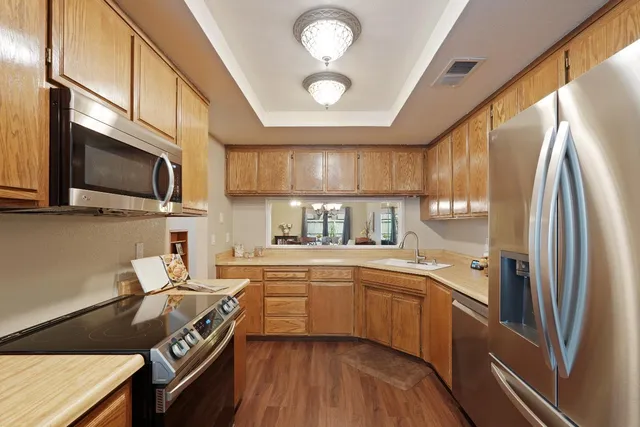 a kitchen with a sink stainless steel appliances and cabinets