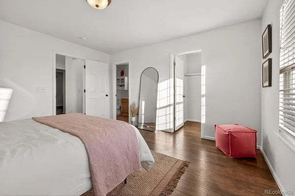 a spacious bedroom with a bed and wooden floor