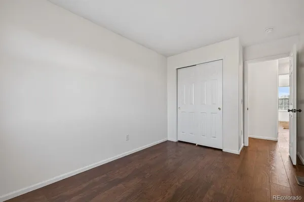 a view of an empty room with wooden floor
