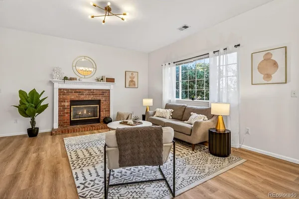 a living room with furniture a fireplace and a table
