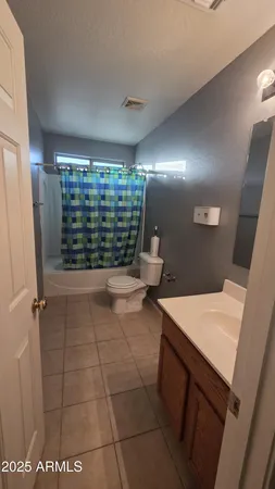 an empty room with chandelier fan and windows