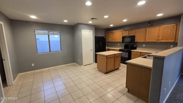 a kitchen with a sink a refrigerator and cabinets