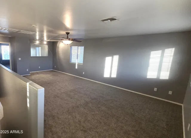 an empty room with a ceiling fan and a window