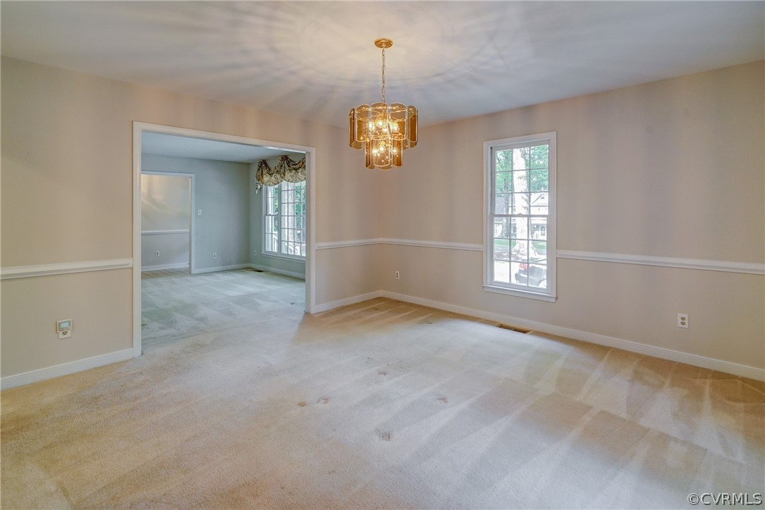 3909 Cheyenne Road Richmond, VA 23235 - Photo 17 of 47 an empty room with windows and chandelier