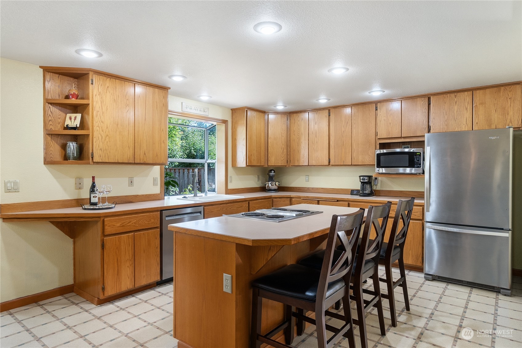 2540 Walnut Loop Northwest Olympia, WA 98502 - Photo 11 of 30 a kitchen with stainless steel appliances granite countertop a refrigerator a sink a stove a dining table and chairs