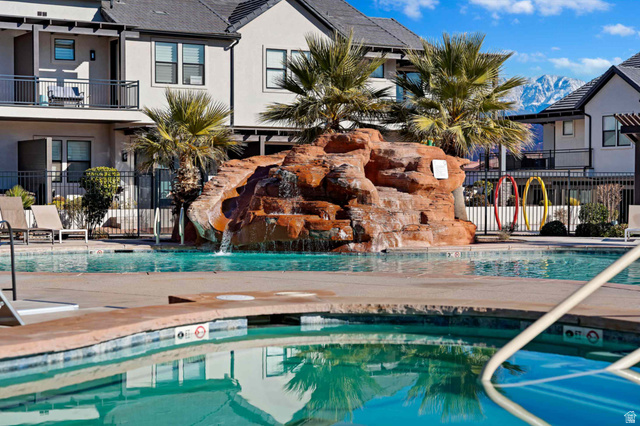 2600 Ocotillo Way, Unit 31 Santa Clara, UT 84765 - Photo 49 of 73 Resort-style pool area featuring a rock-like waterfall, integrated spa, and surrounding palm trees