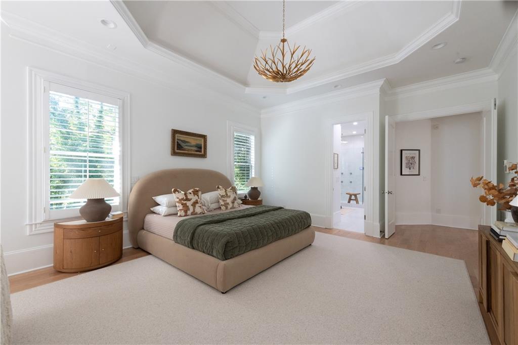 2079 Old Settlement Road Northwest Atlanta, GA 30327 - Photo 29 of 78 a spacious bedroom with a bed and a chandelier