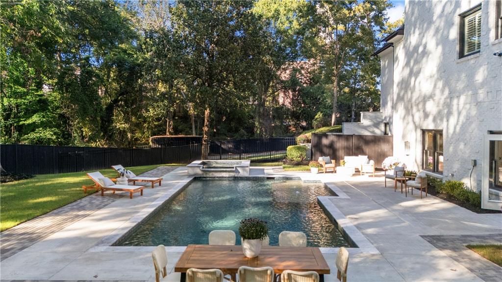 2079 Old Settlement Road Northwest Atlanta, GA 30327 - Photo 58 of 78 a view of a swimming pool with lawn chairs under an umbrella