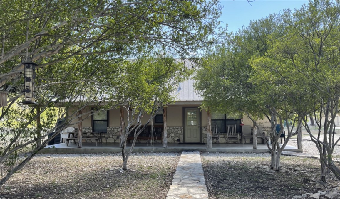 197 Tomahawk Way Concan, TX 78838 - Photo 11 of 18 a front view of a house with trees