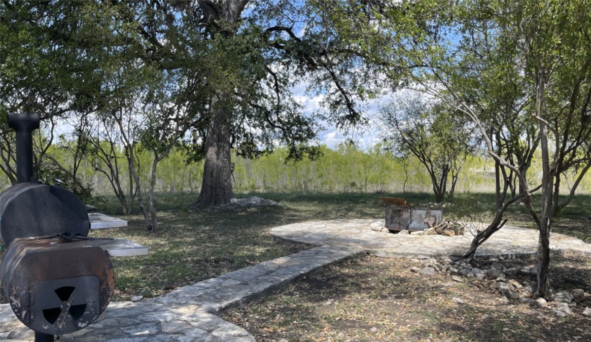 197 Tomahawk Way Concan, TX 78838 - Photo 13 of 18 a backyard of a house with lots of green space