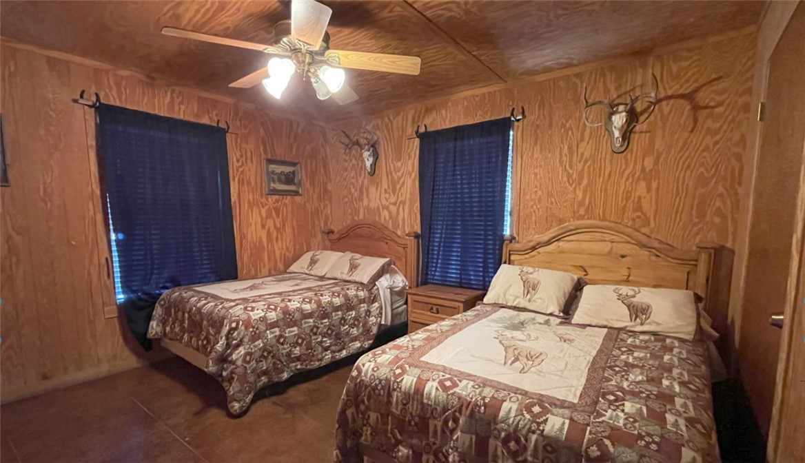 197 Tomahawk Way Concan, TX 78838 - Photo 5 of 18 a bedroom with two beds and a chandelier