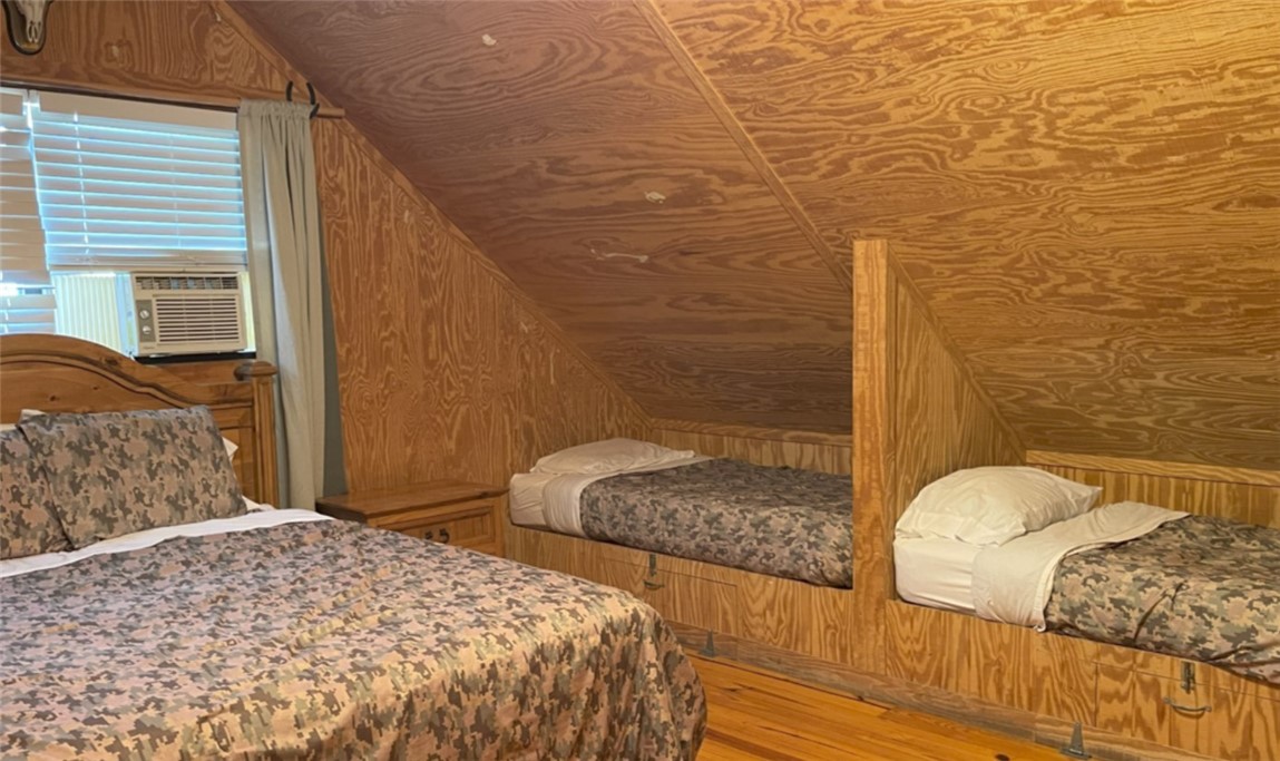 197 Tomahawk Way Concan, TX 78838 - Photo 10 of 18 a bedroom with a bed and wooden floor