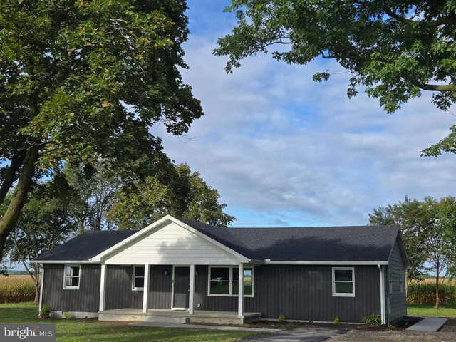 a front view of a house with a garden and trees