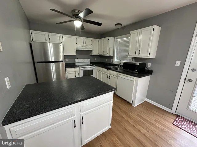 a kitchen with stainless steel appliances granite countertop a refrigerator a stove top oven a sink and dishwasher