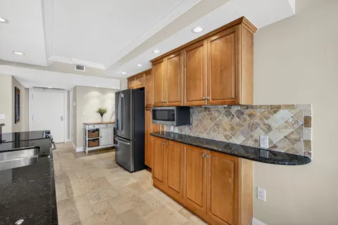 a kitchen with stainless steel appliances granite countertop a refrigerator and microwave