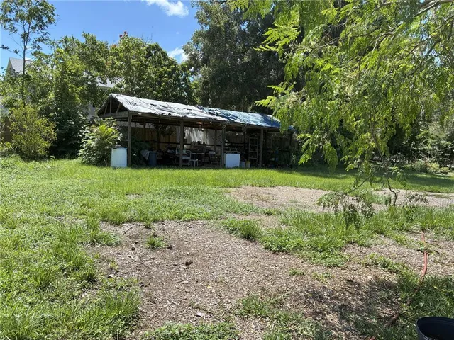 a view of a chair and table in backyard of the house