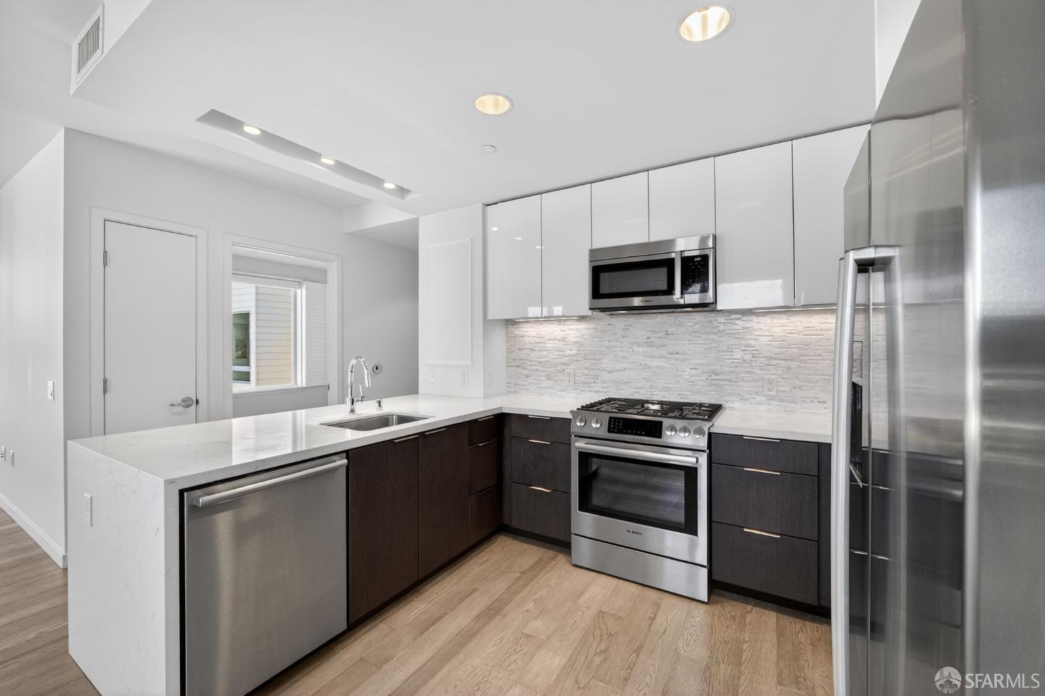 10 Innes Court, Unit 401 San Francisco, CA 94124 - Photo 14 of 33 a kitchen with a sink and steel stainless steel appliances