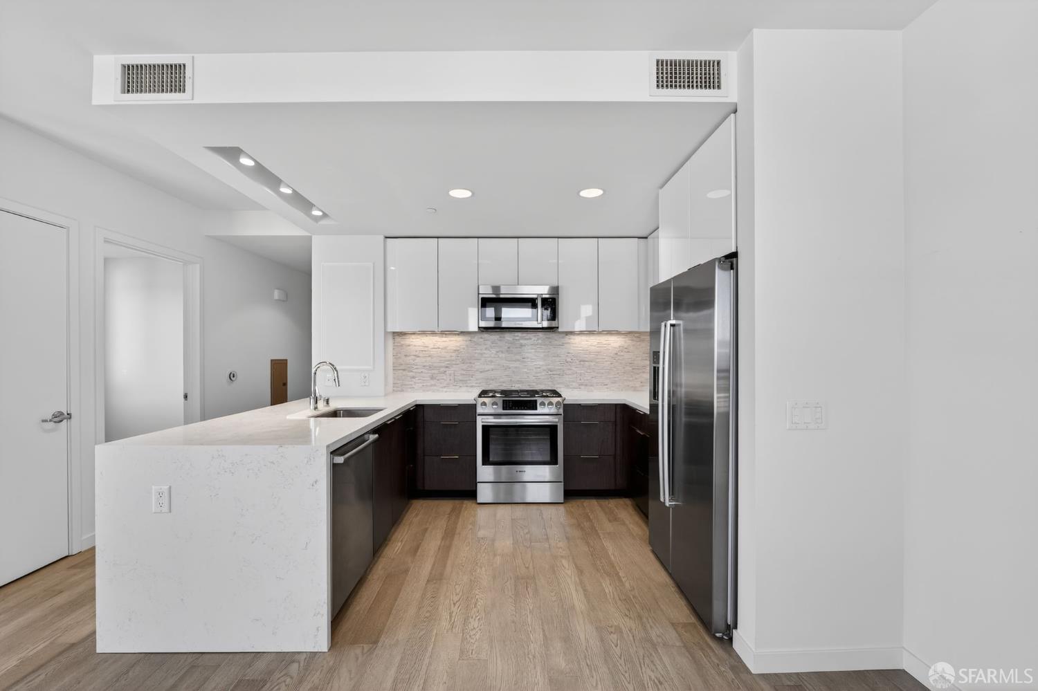 10 Innes Court, Unit 401 San Francisco, CA 94124 - Photo 10 of 33 a large kitchen with stainless steel appliances granite countertop a stove and a refrigerator
