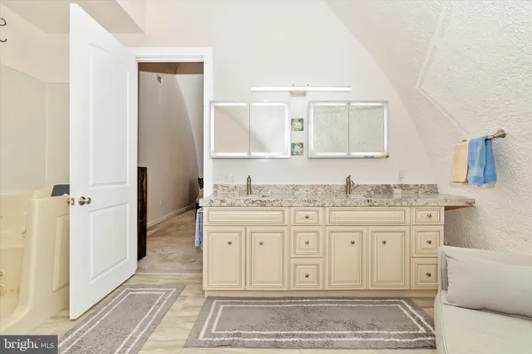 a bathroom with a granite countertop sink and a mirror