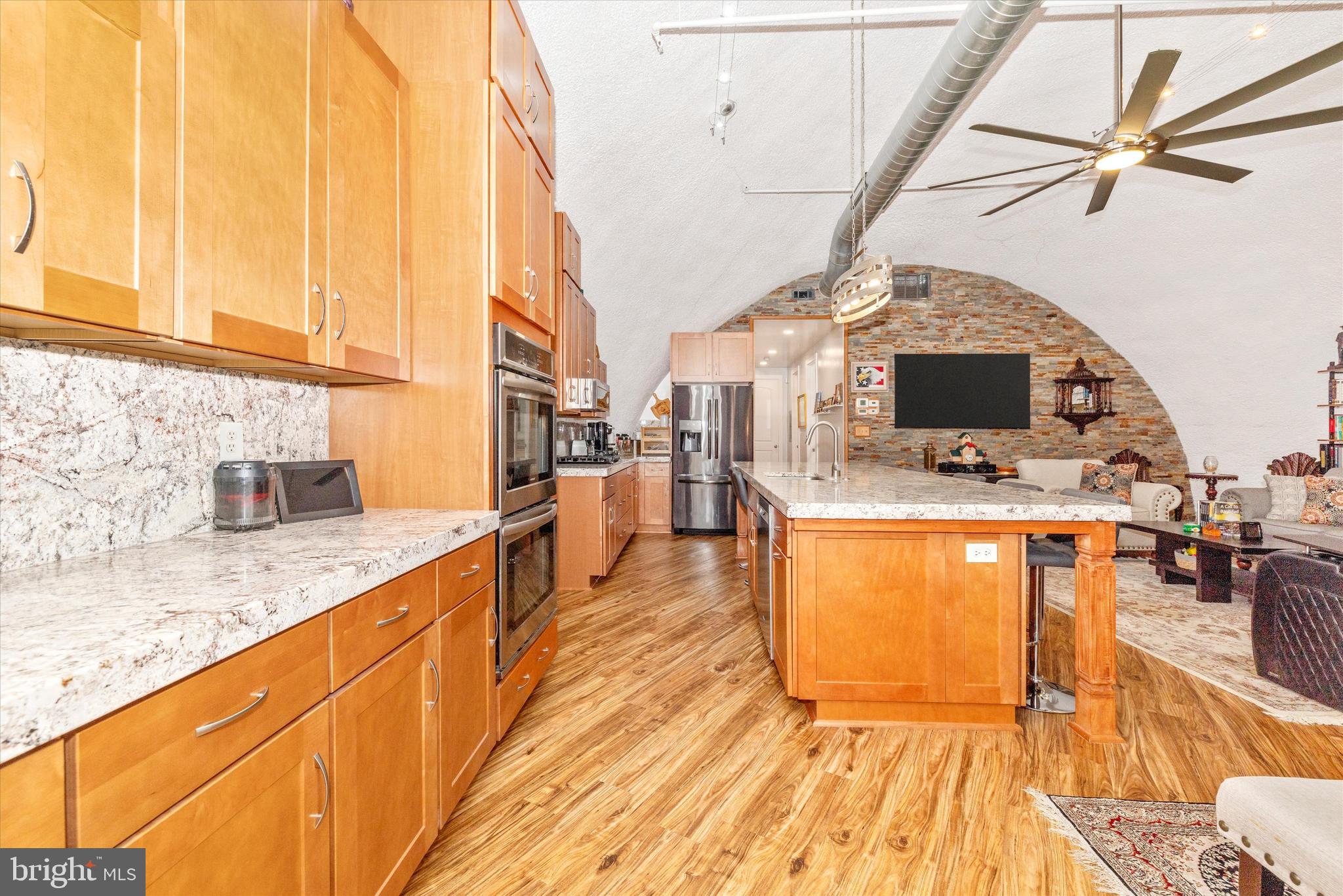 4940 Fox Tower Road Smithsburg, MD 21783 - Photo 5 of 41 a kitchen with stainless steel appliances granite countertop a sink a stove top oven a chimney and living room view