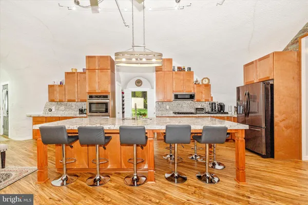 a kitchen with a table chairs stove and wooden floor