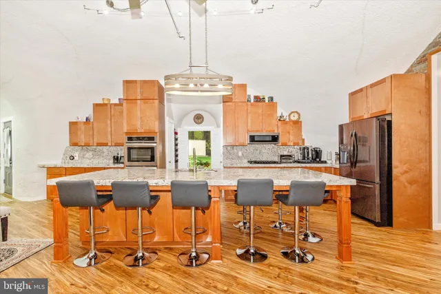 a kitchen with a table chairs stove and wooden floor