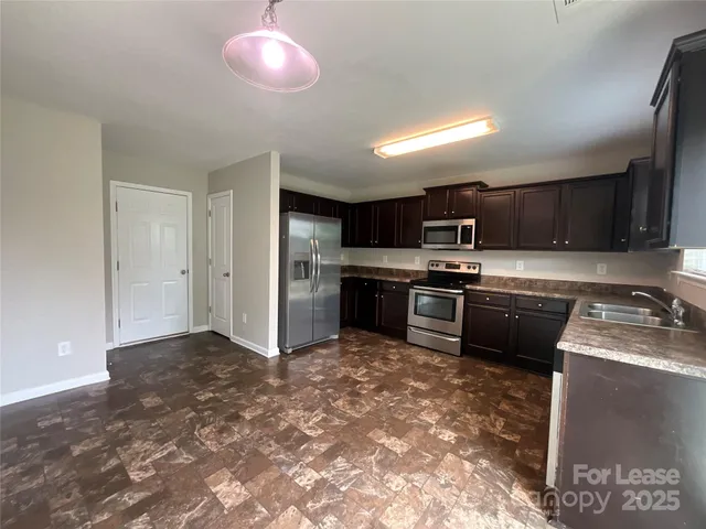 a kitchen with kitchen island granite countertop stainless steel appliances and a sink