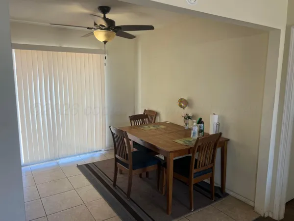 a view of a dining room with furniture and a chandelier fan