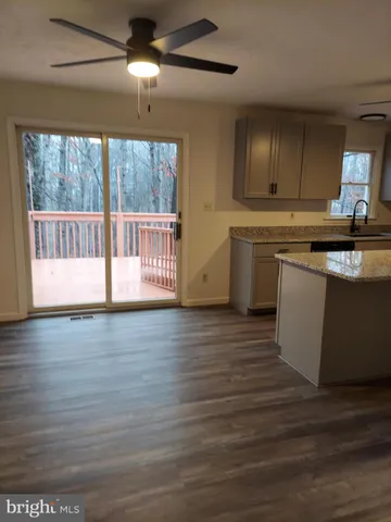 a kitchen with granite countertop a stove and a wooden floors