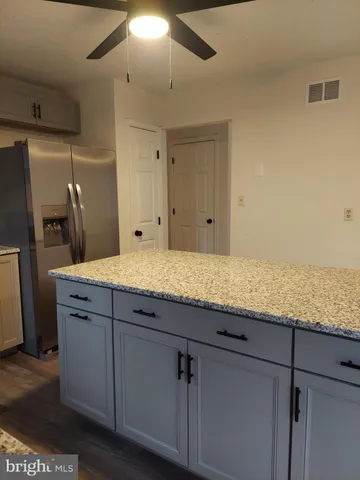 a bathroom with a granite countertop sink and a refrigerator