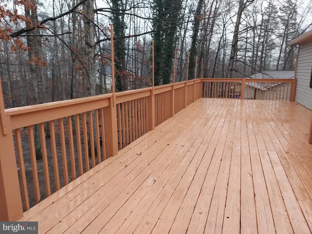 a view of backyard with deck and trees