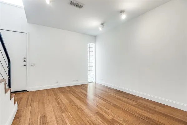 an empty room with wooden floor and white walls