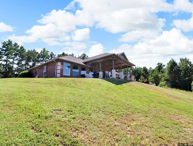 a house view with swimming pool and trees in the background