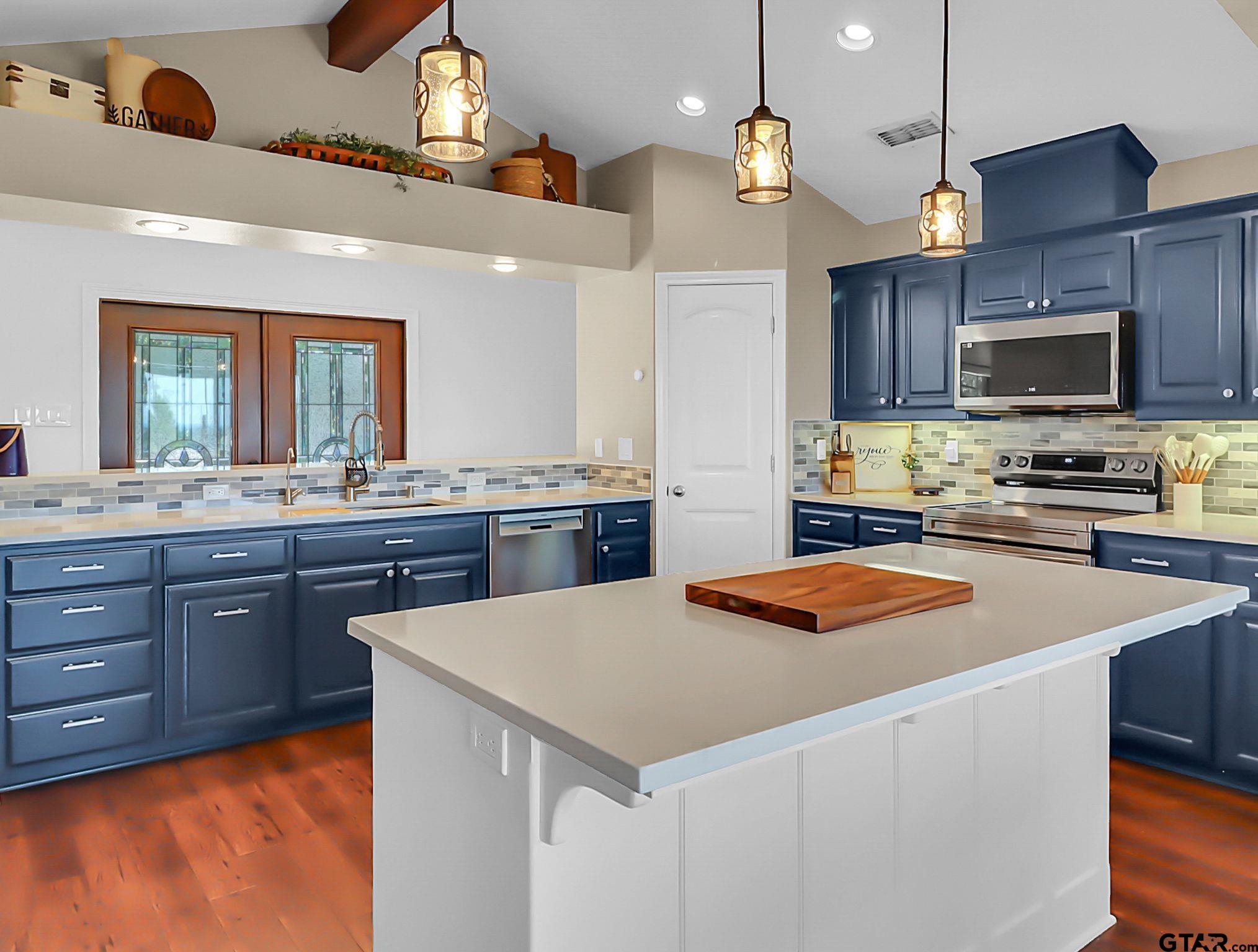 307 Roesch Road Hallsville, TX 75650 - Photo 11 of 40 a kitchen with stainless steel appliances kitchen island granite countertop a sink dishwasher a stove and a refrigerator with wooden floor