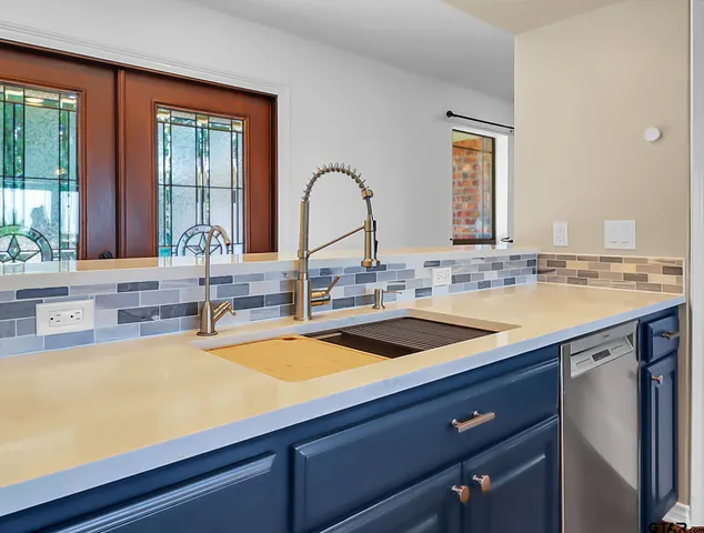 a view of a kitchen counter top a sink and cabinets
