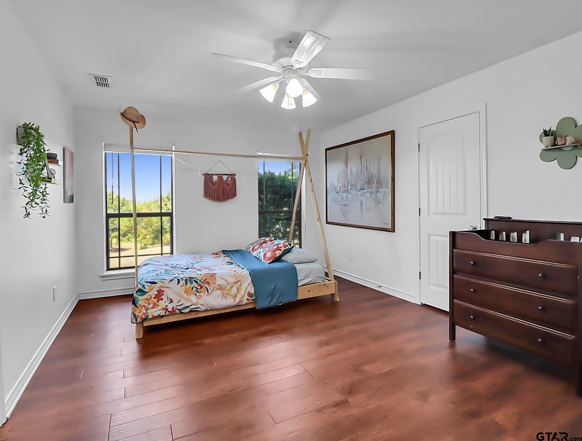 307 Roesch Road Hallsville, TX 75650 - Photo 17 of 40 a bedroom with a bed and wooden floor