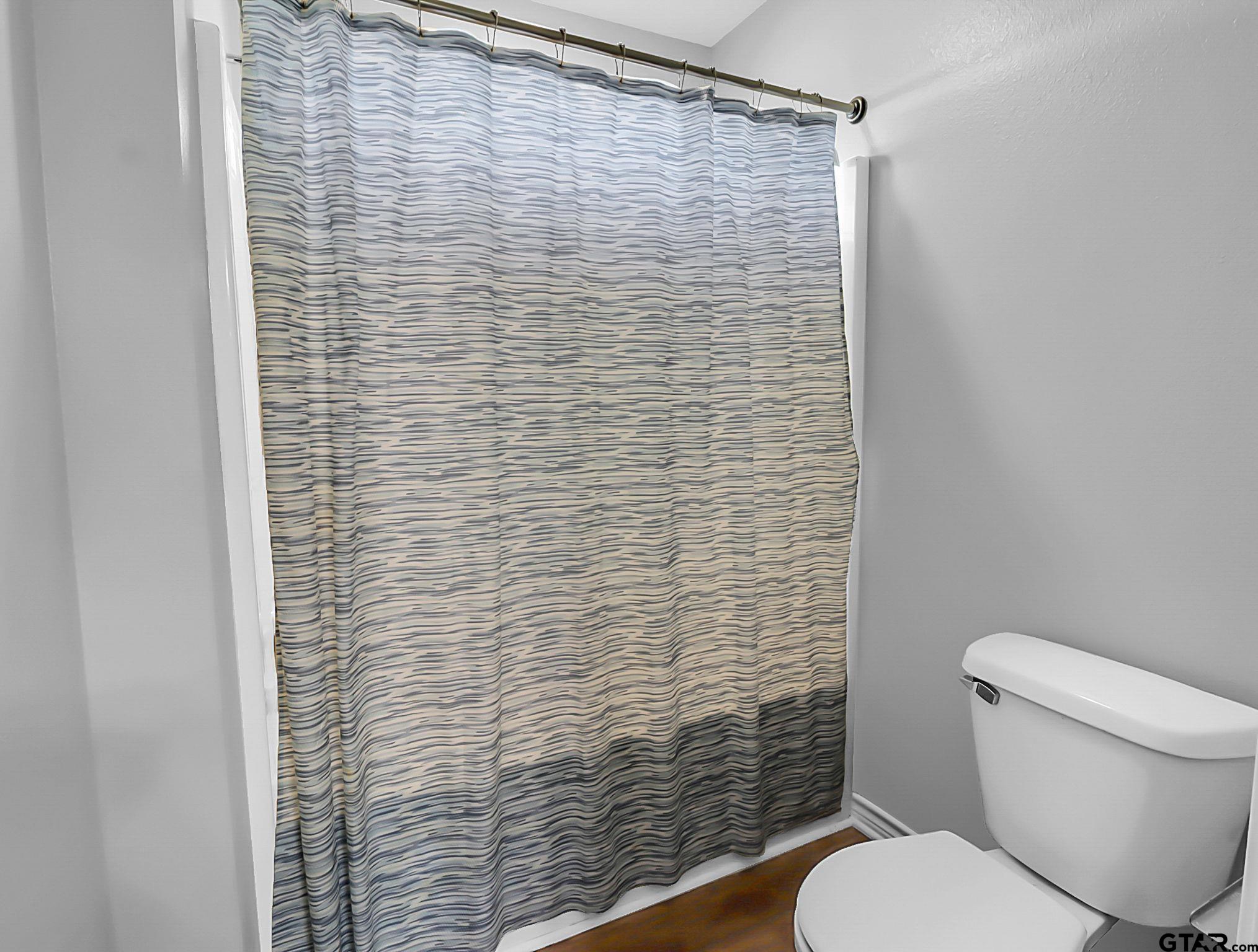 307 Roesch Road Hallsville, TX 75650 - Photo 20 of 40 a bathroom with a toilet and a shower curtain