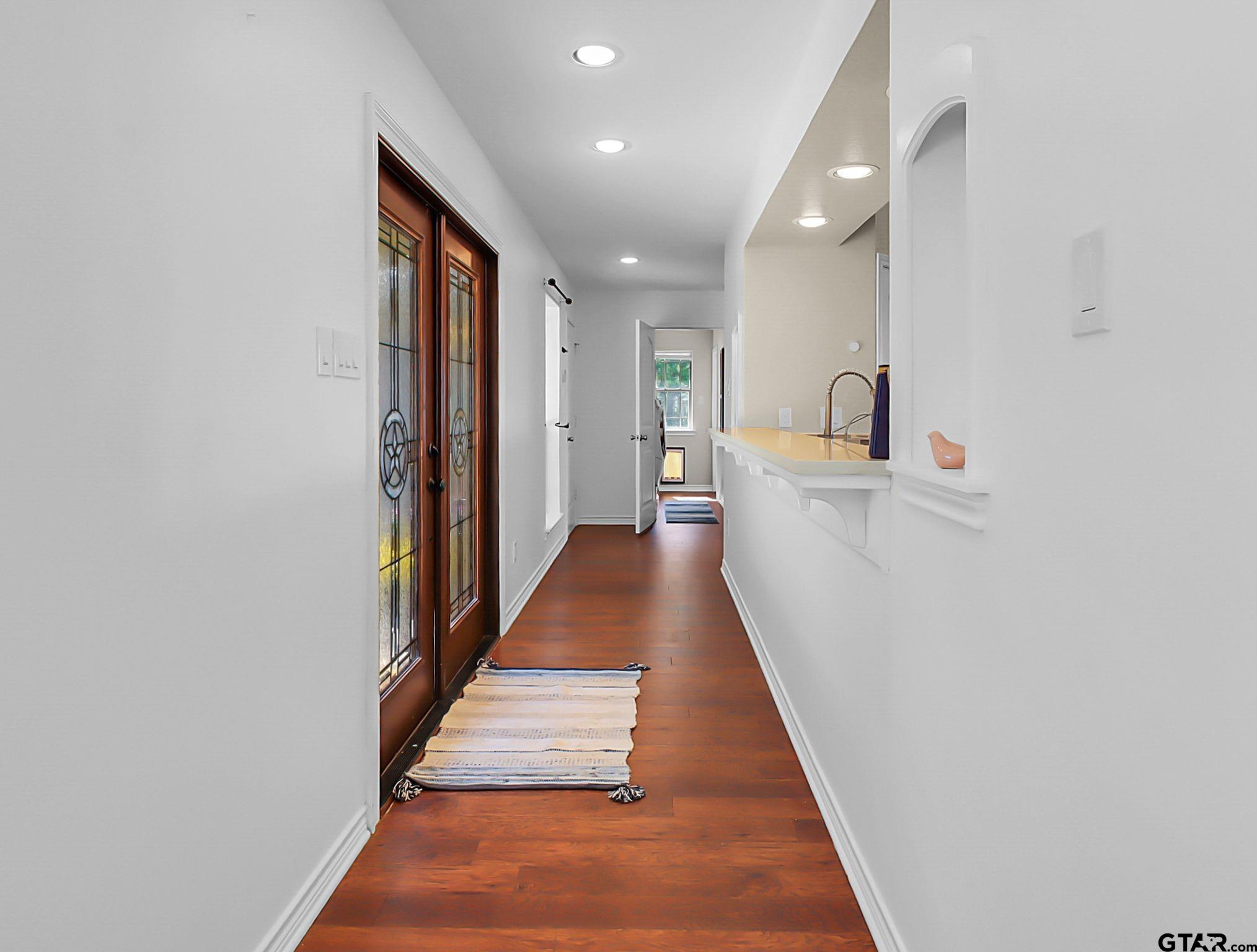 307 Roesch Road Hallsville, TX 75650 - Photo 30 of 40 a hallway with white cabinets and wooden floor